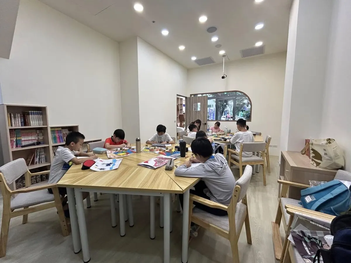 老師好小學堂樂學班：孩子們在書牆旁的大桌完成作業與主題創作